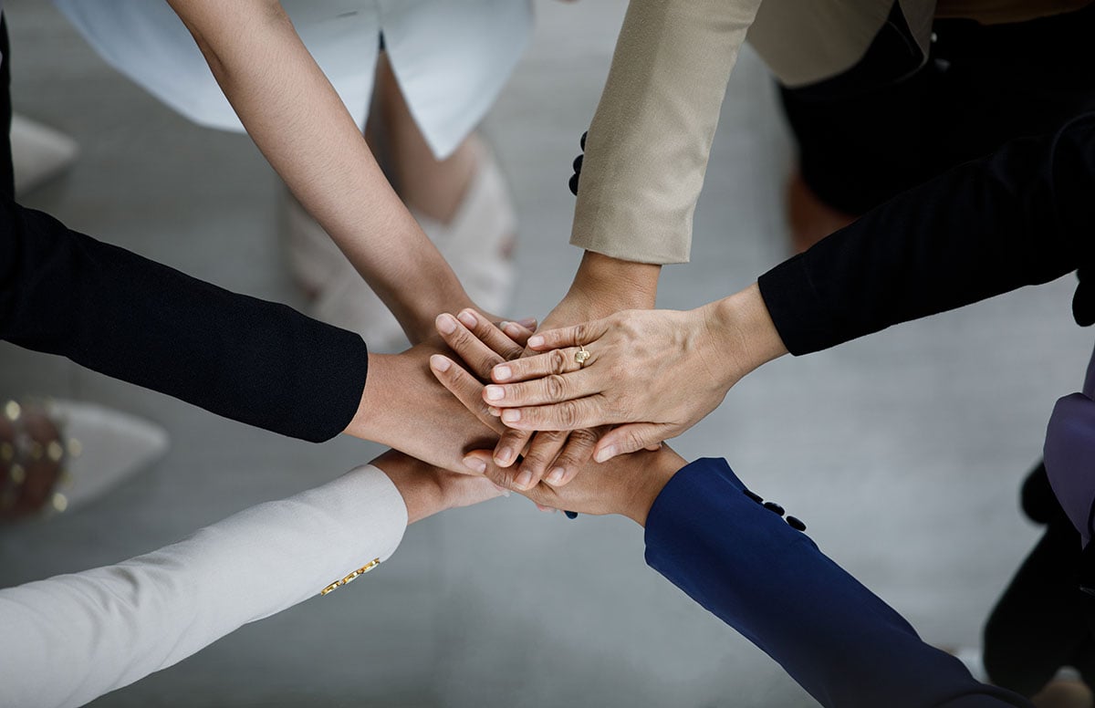 Team members joining hands together
